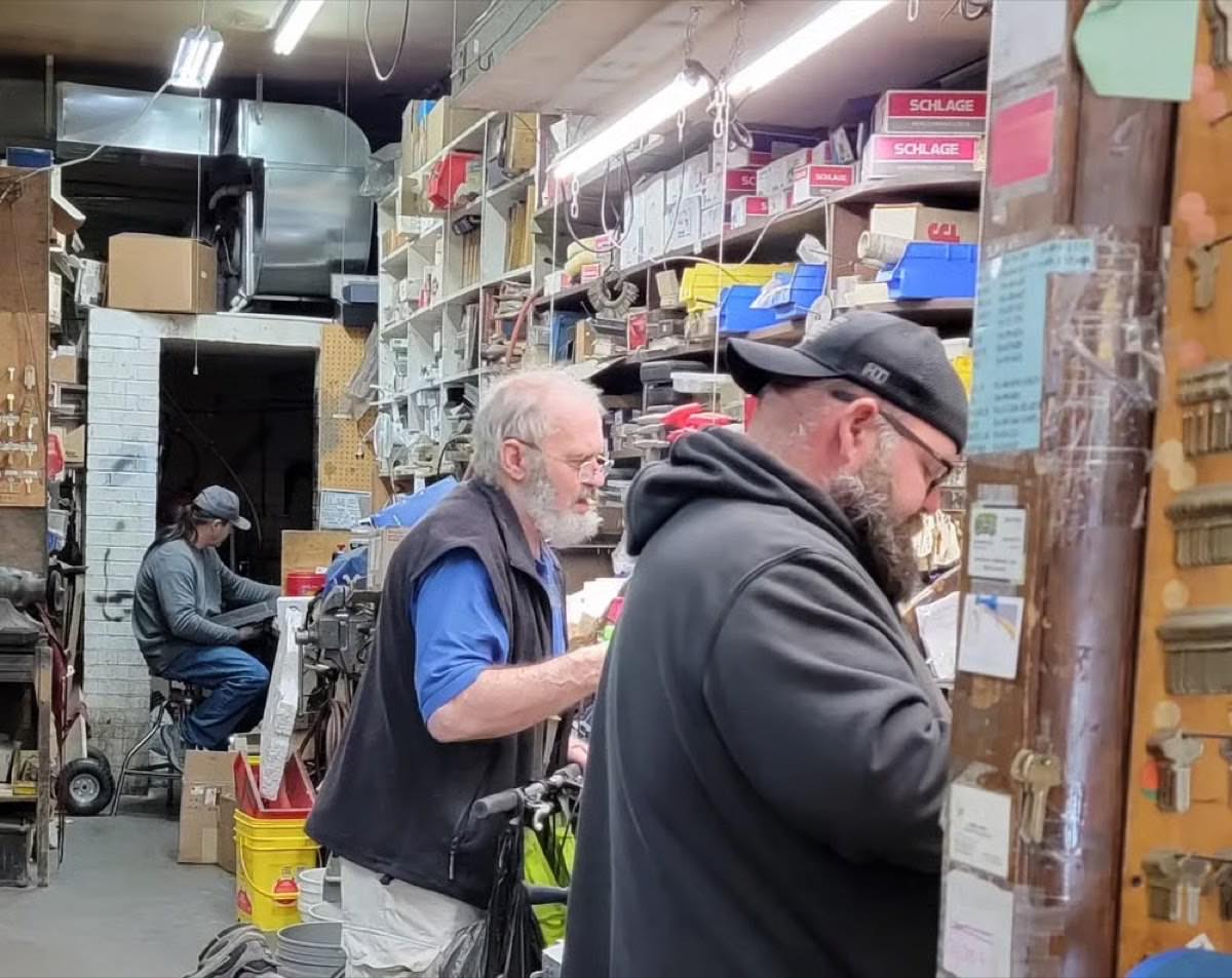 Central Key & Safe locksmiths working the back bench, with shelves of Schlage boxes and key blanks
